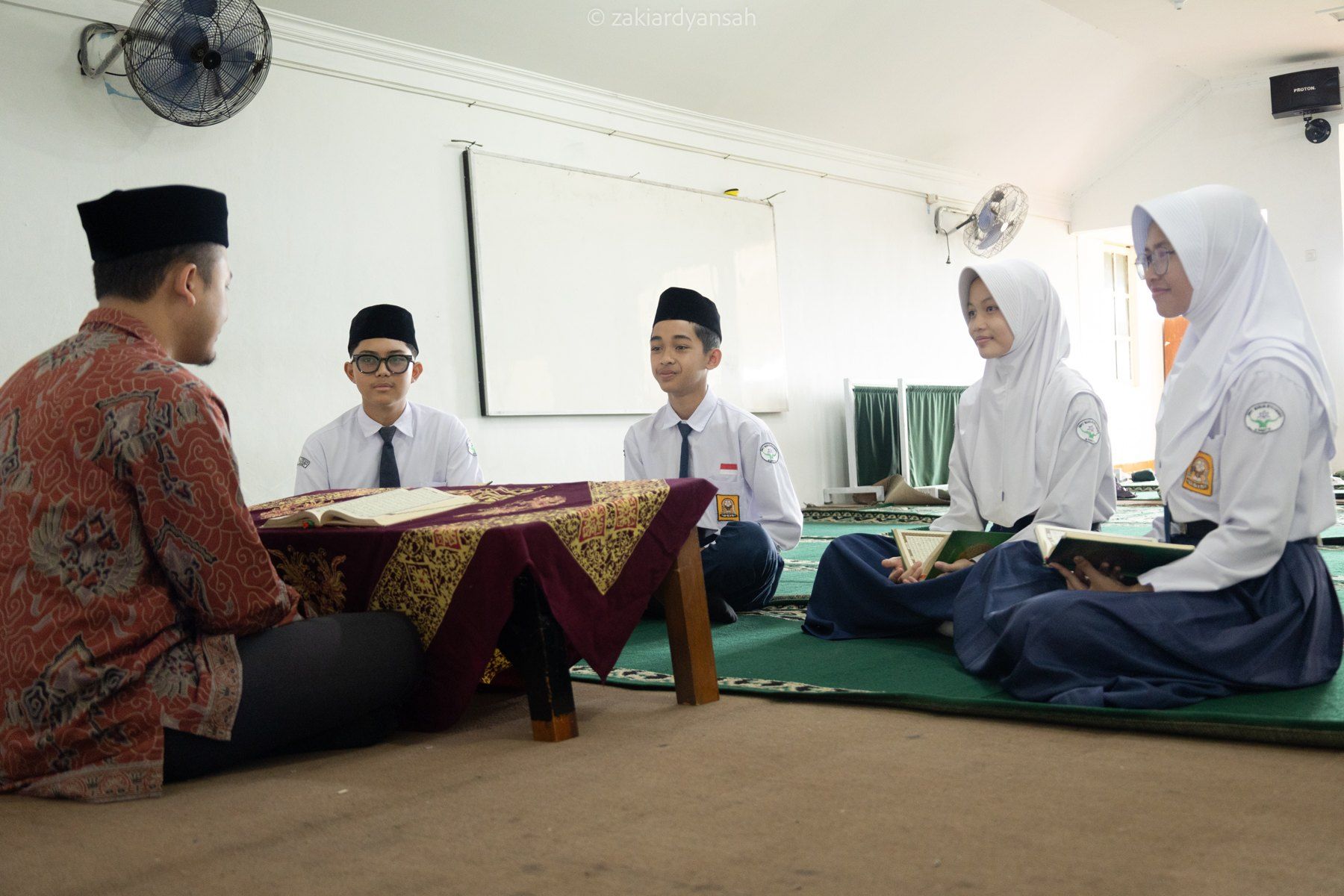 Guru mendampingi siswa dalam pembelajaran tahsin Al-Qur’an.